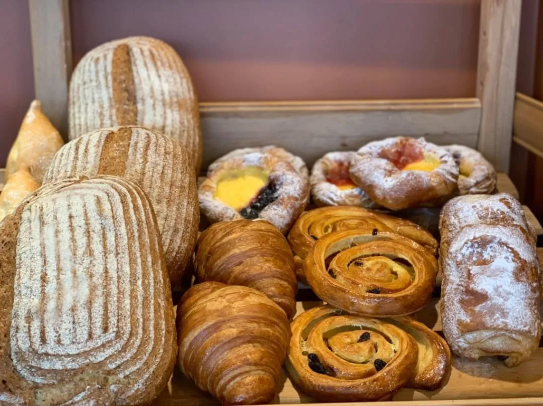 Sourdough loaves, croissants and danishes on a shelf