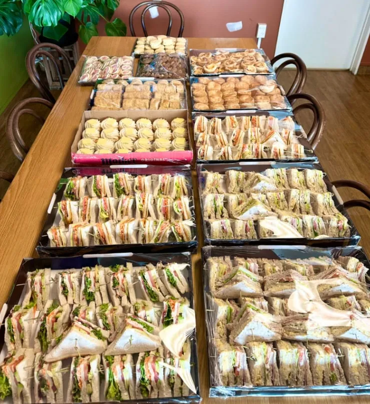 A long table covered in sandwich, savoury and sweet platters