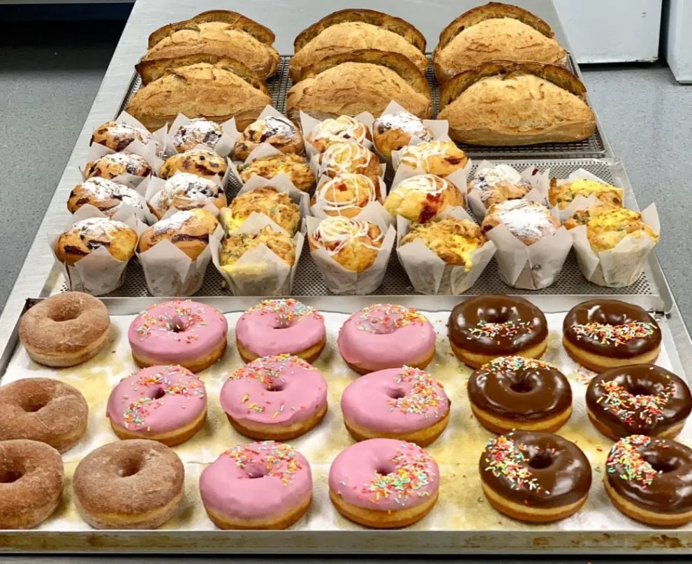 Trays of donuts, muffins and loaves of bread