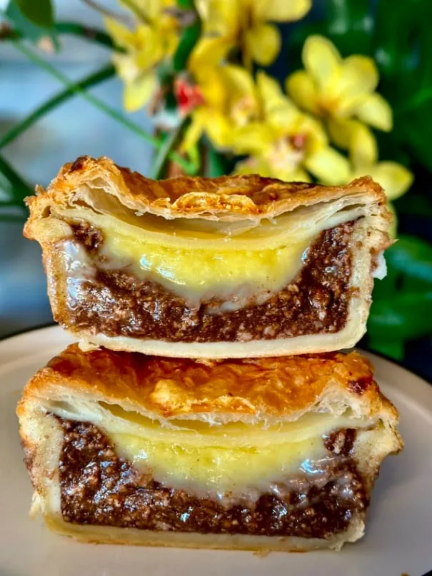 Two halves of a mince and cheese pie stacked on a plate