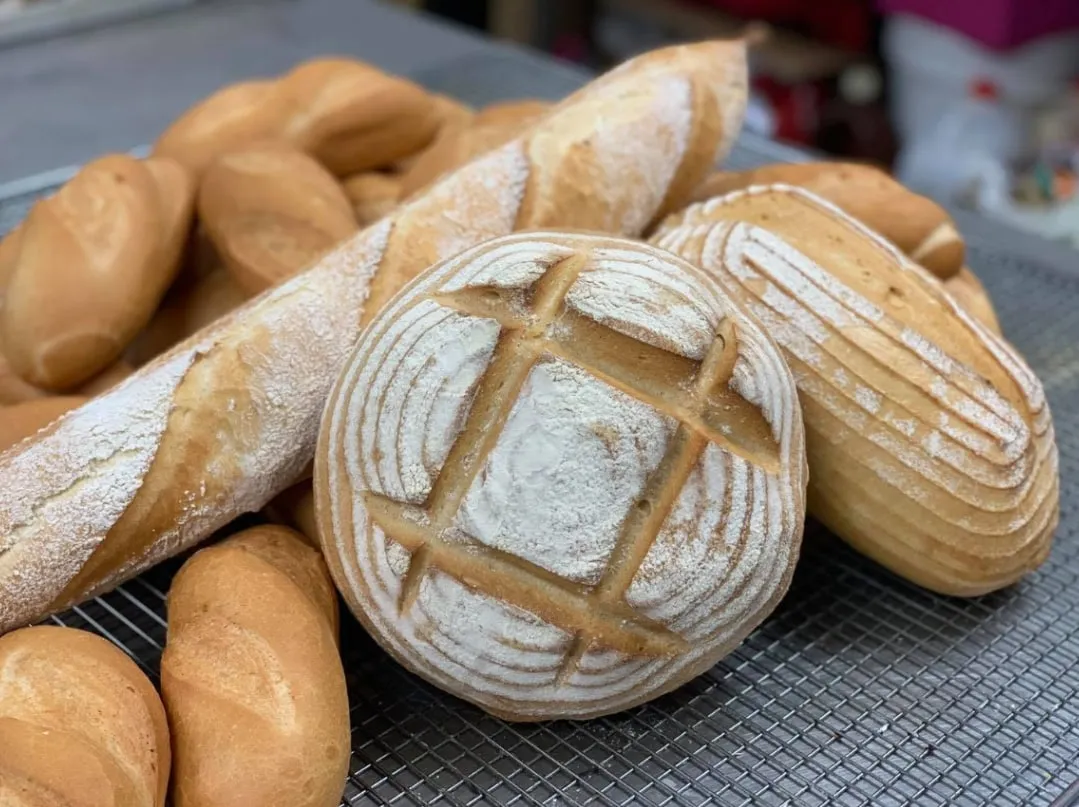 Sourdough and baguettes on a cooling rack